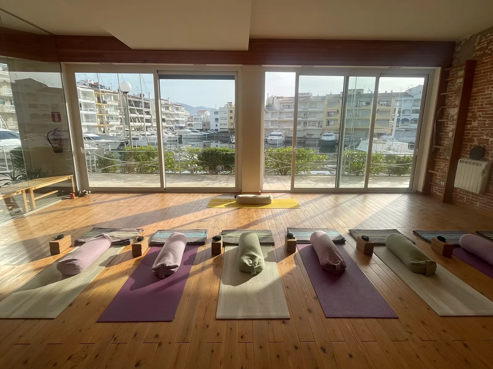 Sala Yoga del Mar en Empuriabrava, esterillas preparadas con luz natural y vistas al canal